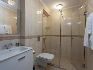 a bathroom with a shower and a toilet and a sink at Antik Apartments in Balchik +32 photos