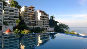 a view of some apartment buildings from a swimming pool at Casa Cupula LGBT Luxury Resort in Puerto Vallarta +19 photos