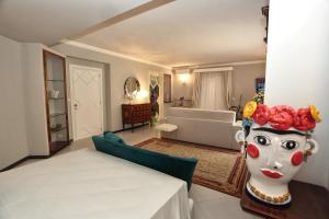 una camera con un letto e una stanza con una maschera di Al Duomo Rooms & Flats a Taormina