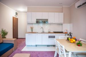 a kitchen with white cabinets and a table with fruit on it at Apartamenty Niegocin in Wilkasy