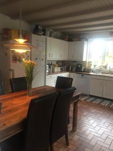 a kitchen with a wooden table with a vase of flowers on it at Køge Bed & Kitchen - Rooms in Køge