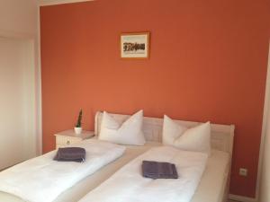 two beds in a room with orange walls at Ferienhaus Frankstraße 5b in Zinnowitz