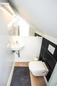 a bathroom with a white toilet and a sink at Apartamenty SaltApart2 in Wieliczka +25 photos