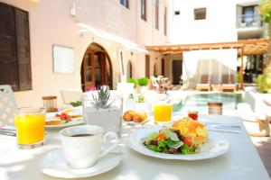 einen Tisch mit Tellern und einer Tasse Kaffee in der Unterkunft Pepi Boutique Hotel (Adults Only) in Rethymno