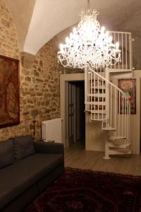 sala de estar con lámpara de araña y escalera en Casa enzo, en Arezzo