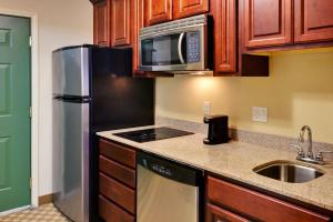 a kitchen with a refrigerator microwave and a sink at Country Suites Absecon-Atlantic City, NJ in Galloway