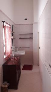 a white bathroom with a sink and a mirror at Casa Millenovecento in Brindisi