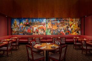 a dining room with tables and a large painting on the wall at Millennium Hotel Broadway Times Square in New York