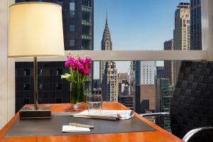 a table with a vase of flowers and a window at Millennium Hotel Broadway Times Square in New York