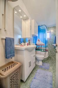 a bathroom with a sink and a toilet and a mirror at Apartman Ana in Štinjan