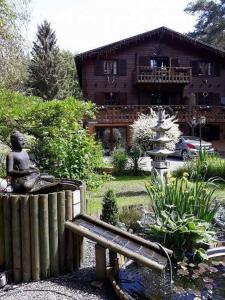 a garden with a statue and a fountain in front of a house at Romantica Exotica in Biron