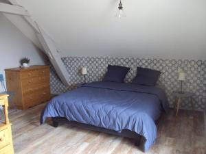 - une chambre avec un lit doté de draps bleus et un escalier dans l'établissement Tartine & Polochon, à Longué