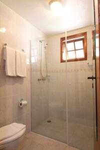 La salle de bains est pourvue d'une douche et de toilettes. dans l'établissement Pousada Il Villaggio, à Santo Antônio do Pinhal