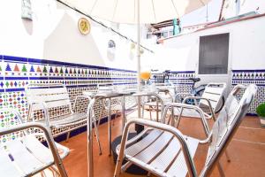 マラガにあるLetmalaga Sweet Familyの白い椅子とテーブル、傘が備わる空きレストランです。