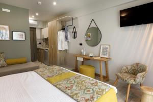una camera con letto, tavolo e specchio di Kallini Apartments a Stavros