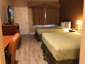 a hotel room with two beds and a flat screen tv at Valley Inn in Watsonville