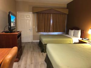 a hotel room with two beds and a flat screen tv at Valley Inn in Watsonville