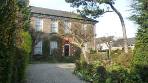 una vieja casa de ladrillo con un jardín delante de ella en Holly Lodge, en York