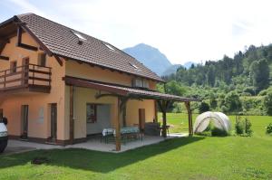 a house with a gazebo in a field at Apartma Jernej in Bovec