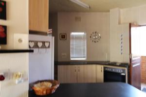 a kitchen with a black counter top and a refrigerator at Seeskulp 10 in Margate