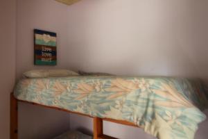 ein Bett mit einer Bettdecke und Blumen darauf in der Unterkunft Seeskulp 10 in Margate