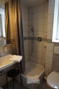 a bathroom with a tub and a sink and a shower at Ringhotel Altstadt in Güstrow +24 photos