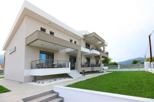 een groot huis met een gazon ervoor bij Kallini Apartments in Stavros