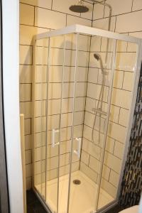 a shower with a glass enclosure in a bathroom at Hameau des Essarts in Grand-Couronne