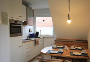 a kitchen with a table with plates and cups on it at Ferienwohnung Muhlichen in Carolinensiel