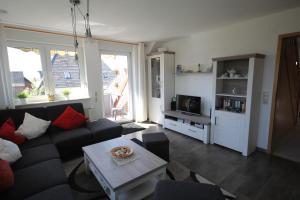 a living room with a couch and a table at Ferienwohnung Muhlichen in Carolinensiel