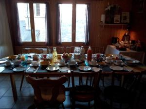 a wooden table with plates and bowls on it at La Cure de Vernamiège in Vernamiège
