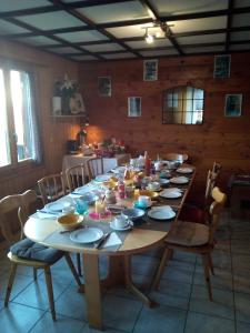 a large wooden table with plates and bowls on it at La Cure de Vernamiège in Vernamiège