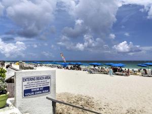 a beach with umbrellas and people sitting on the sand at Oceanview on BEACH Fort Lauderdale located in resort, large 2 bedroom corner unit partial ocean view in Fort Lauderdale
