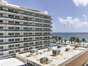 a large building on the beach next to the ocean at Oceanview on SAND located in Ocean Manor Resort Fort Lauderdale Beach 2 bed 2 bath spacious corner unit partial ocean view in Fort Lauderdale