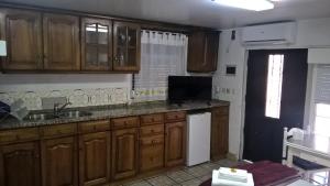 a kitchen with wooden cabinets and a sink at Casa do Limoeiro in Quinta do Conde