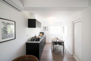 a kitchen with a black counter and a table at Quinta do Meco - Beach & Nature in Aldeia do Meco