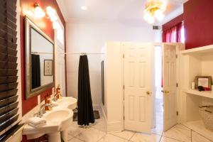 
a bathroom with a sink, toilet, and shower at Auberge NOLA Hostel in New Orleans

