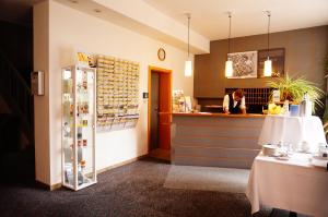 a restaurant with a counter and a woman in a kitchen at Ringhotel Altstadt in Güstrow