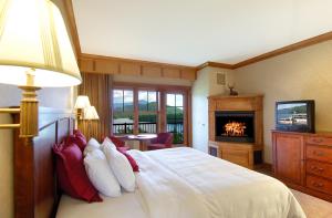 a bedroom with a bed with a fireplace and a television at Crowne Plaza Lake Placid, an IHG Hotel in Lake Placid