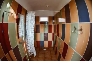 a bathroom with multicolored tiles on the wall at Sunny Nights Homestead Rustic House in Gataučiai