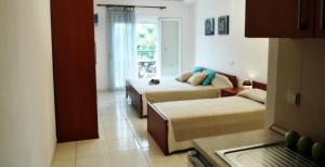 - un salon avec deux lits et un canapé dans l'établissement Asterias Hotel, à Porto Koufo