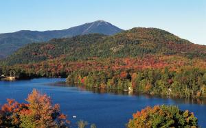 een meer in het midden van een bos met een berg bij Crowne Plaza Lake Placid, an IHG Hotel in Lake Placid