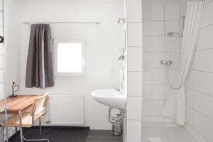 ein Badezimmer mit einem Tisch, einem Waschbecken und einer Dusche in der Unterkunft Hotel Residenz in Ravensburg