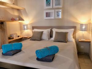 uma cama grande com duas almofadas azuis em Little Star em Antibes
