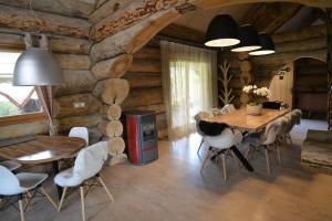 ein Esszimmer in einem Blockhaus mit einem Tisch und Stühlen in der Unterkunft Le Chalet de Lyne in Erckartswiller