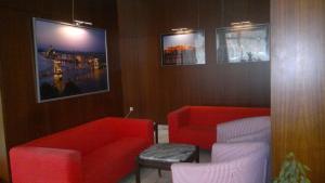 a living room with two red chairs and a tv at Budapest Center House in Budapest
