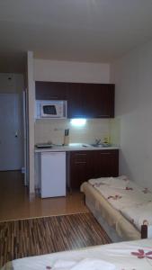 a room with two beds and a kitchen with a microwave at Budapest Center House in Budapest