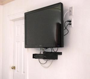 einen Flachbild-TV, der an einer Wand hängt in der Unterkunft Apache Inn in Lynwood
