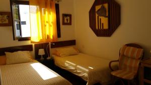 プラヤ・ブランカにあるTisalaya Girigaray nº25のベッド2台、椅子、窓が備わる客室です。