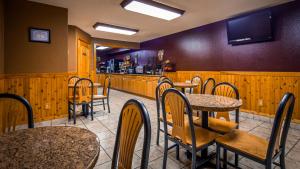 a restaurant with tables and chairs and a bar at Best Western Inn Of Pinetop in Pinetop-Lakeside